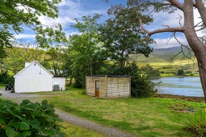 Escape to a serene natural haven surrounded by lush trees and a tranquil body of water.
