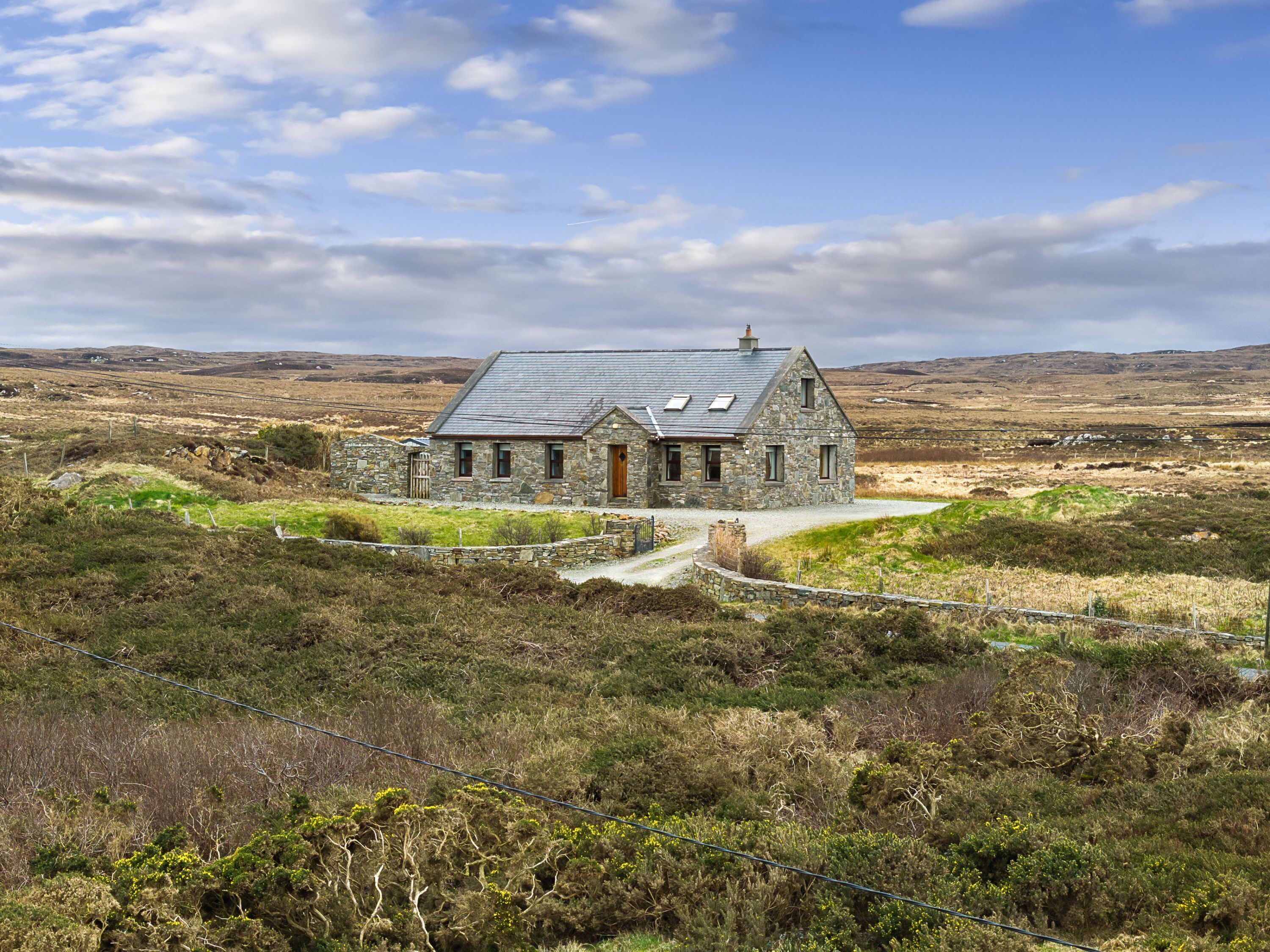A stone house with a sloped roof, a wooden door, and a small porch.