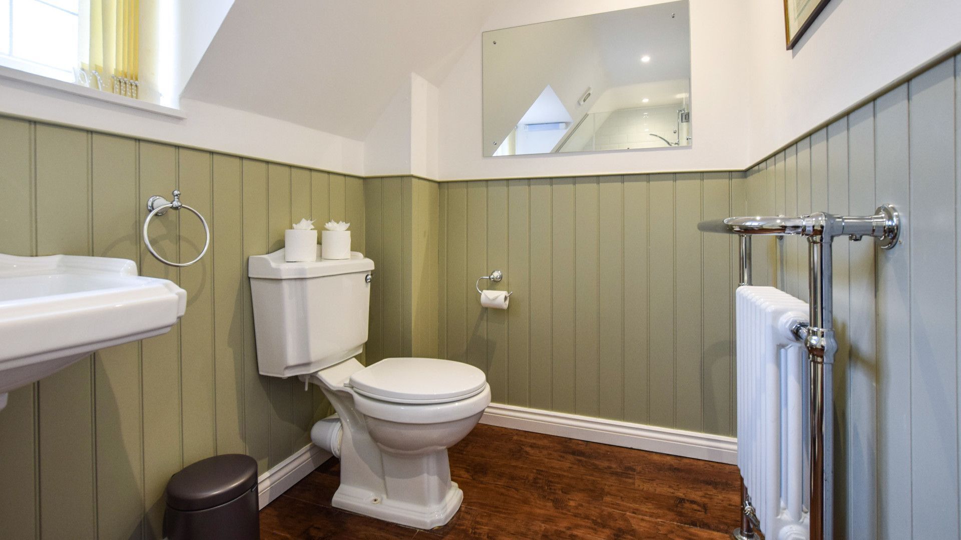 Une salle de bain avec des toilettes, un lavabo et un radiateur.