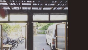 Una habitación con vistas a una calle, bicicletas y una furgoneta estacionada.