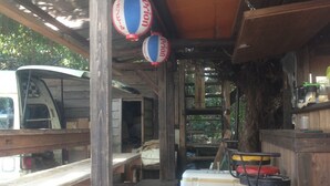 Una estructura rústica de madera con barra, bancos de madera y faroles colgantes.