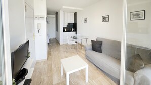 A modern living room with a flat-screen TV, a white coffee table, and a grey sofa. - RIBERA PETIT BY BLAUSITGES Small apartment with superb sea views in Sitges. (SITGES)