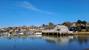 A marina with boats docked, a building labeled "EAST QUAY", and residential houses in the background. - Kipper Cottage  -  a bungalow that sleeps 4 guests  in 2 bedrooms (Ryde)