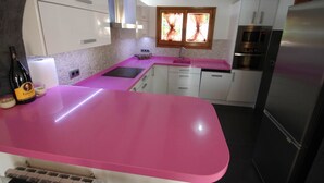 A kitchen with white cabinets, a pink countertop, a stainless steel refrigerator, and a window with curtains. - Kanky 6 - modern, well-equipped villa with private pool in Benissa coast (Benissa)