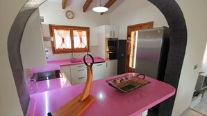 A kitchen with a pink countertop, a wooden cutting board, a basket, and a refrigerator. - Kanky 6 - modern, well-equipped villa with private pool in Benissa coast (Benissa)