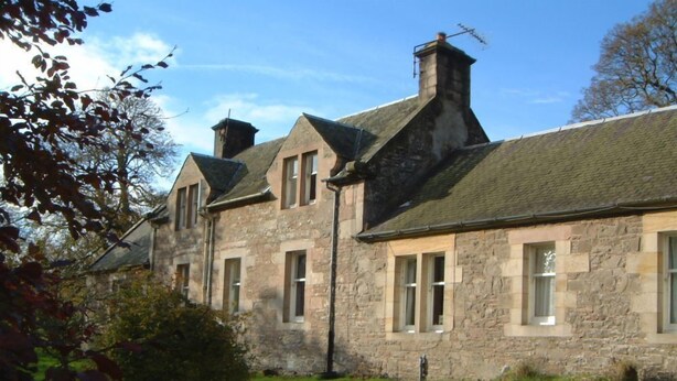 A stone building with multiple windows and a sloped roof. - The Maid's House, Carmichael Country Cottages. 4 star comfortable cottage on rural Estate (Biggar)