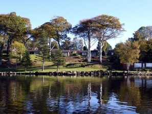 A residential area with houses, trees, and a body of water reflecting the surroundings. - Cottage 11 -  a cottages  that sleeps 6 guests  in 0 bedrooms (Irvinestown)
