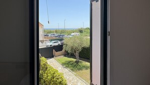 A view through a window of a parking lot with cars and a clear sky. - Daró 3D 56 - 50m from the beach, with pool (Torroella de Montgri)