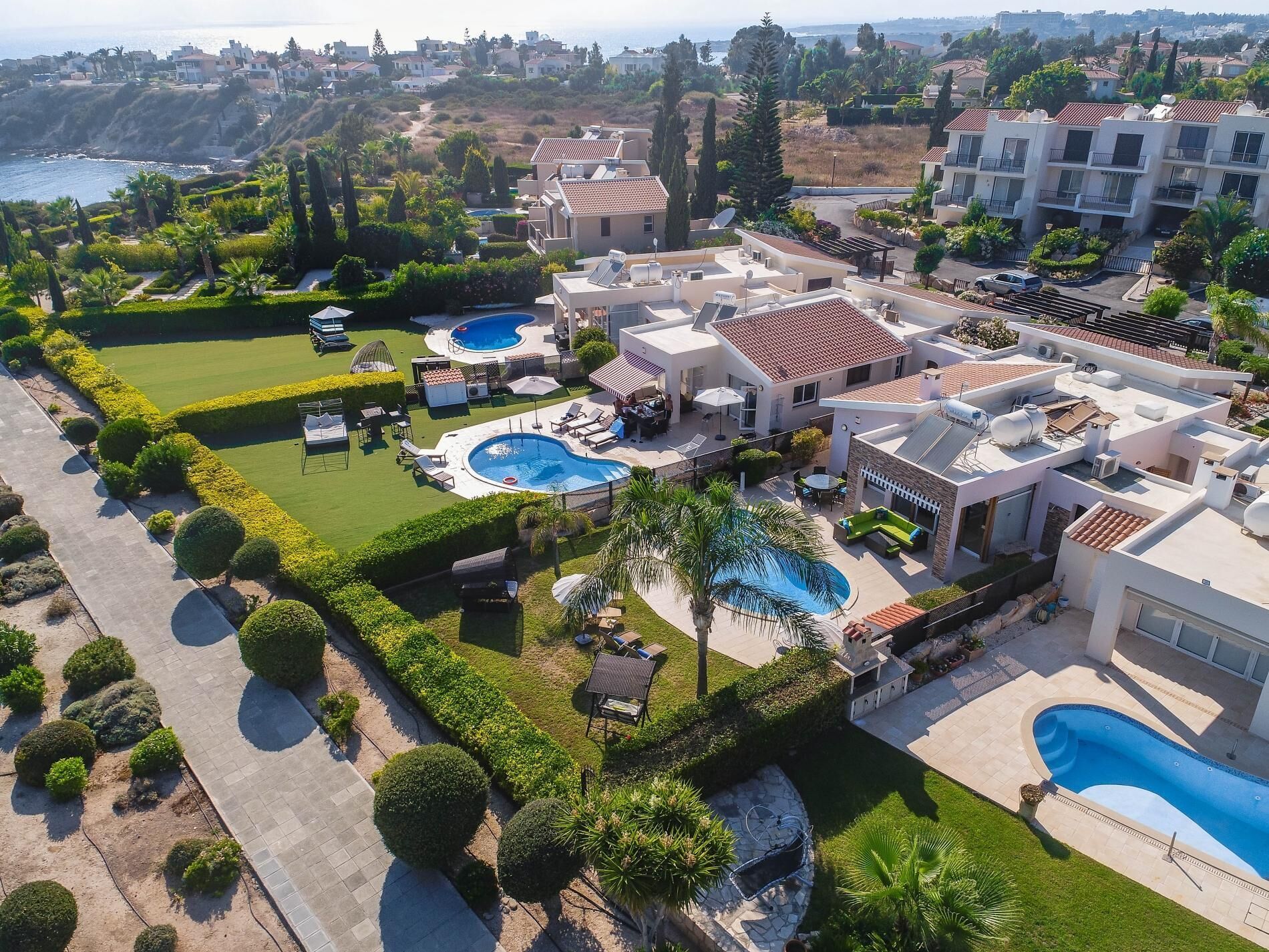 A residential area with multiple houses, a swimming pool, and a well-maintained garden.