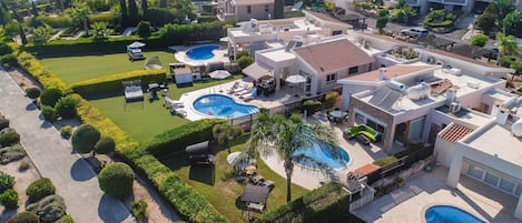 A residential area with multiple houses, a swimming pool, and a well-maintained garden.