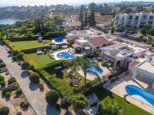 A residential area with multiple houses, a swimming pool, and a well-maintained garden.