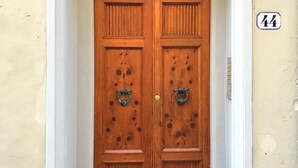 A wooden double door with a number '44' on the wall to the right.