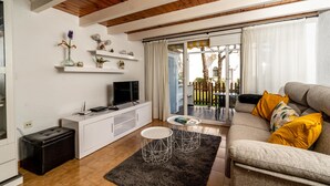 Un salon moderne avec un canapé, une table basse, un téléviseur et une cheminée.