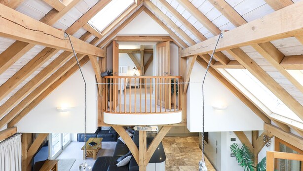 A loft-style room with a wooden ceiling, a balcony, and a view of the interior. - Beach Side -  a house that sleeps 8 guests  in 4 bedrooms (Bembridge)