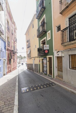 A narrow street with buildings on either side, a 'HappyVila' sign, and a 'STOP' sign. - HAPPY - ESTUDIO VISTAS A CALLE (Villajoyosa)