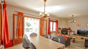 A dining area with a wooden table and chairs, a sofa, and a television in the background. - Bal-30E - traditionally furnished detached villa with peaceful surroundings in Benissa (Benissa)