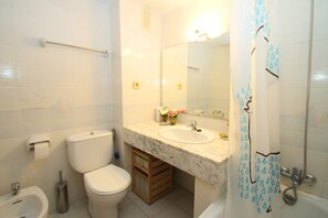 Bathtub, hair dryer, towels, toilet paper