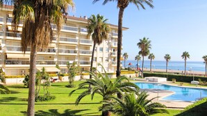 Un hôtel doté d’une piscine, de palmiers et offrant une vue sur la plage.