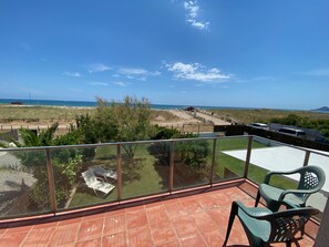 Un balcon offrant une vue dégagée sur une plage et l’océan.