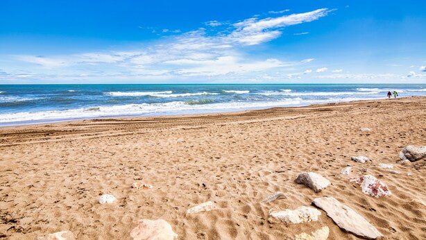 A sandy beach with scattered rocks and a clear blue sky. - Holiday Beach - Denia, Costa Blanca (Denia)