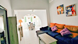 Un soggiorno con divano, tavolino e zona pranzo con sedie e tavolo.