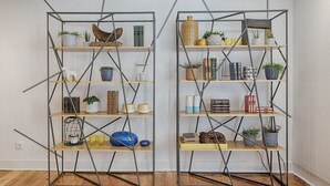Dos estanterías metálicas con diversos objetos decorativos y plantas.