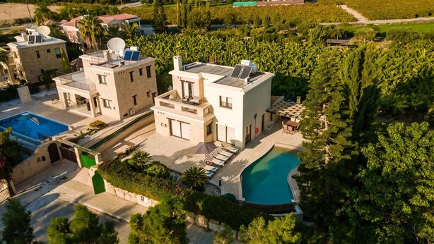 Une villa moderne dotée d’une piscine, de panneaux solaires et d’un jardin luxuriant.
