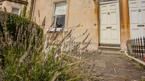 A building with a white door marked with the number 10, a small window, and a stone facade. - The Design Studio (Bath)