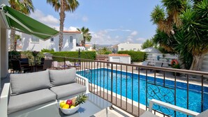 A balcony with a pool, outdoor furniture, and a view of the surrounding area. - Villa Shiva by Ezoria Villas (Coral Bay)