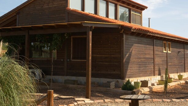 Una casa de madera con techo inclinado y ventanas grandes.