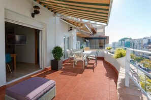A balcony with a table and chairs, a potted plant, and a view of the city. - Atico La JOYITA free parking by Cadiz4Rentals (Cádiz)