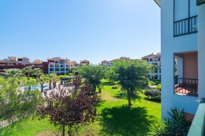 A residential area with a pool, green lawns, and multi-story buildings. - El Rincon del Golf III PLUS - Isla Canela Golf GRHIII88P88 (Isla Canela)
