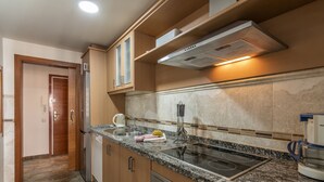 Una cucina moderna con piani di lavoro in granito, elettrodomestici in acciaio inossidabile e forno integrato.