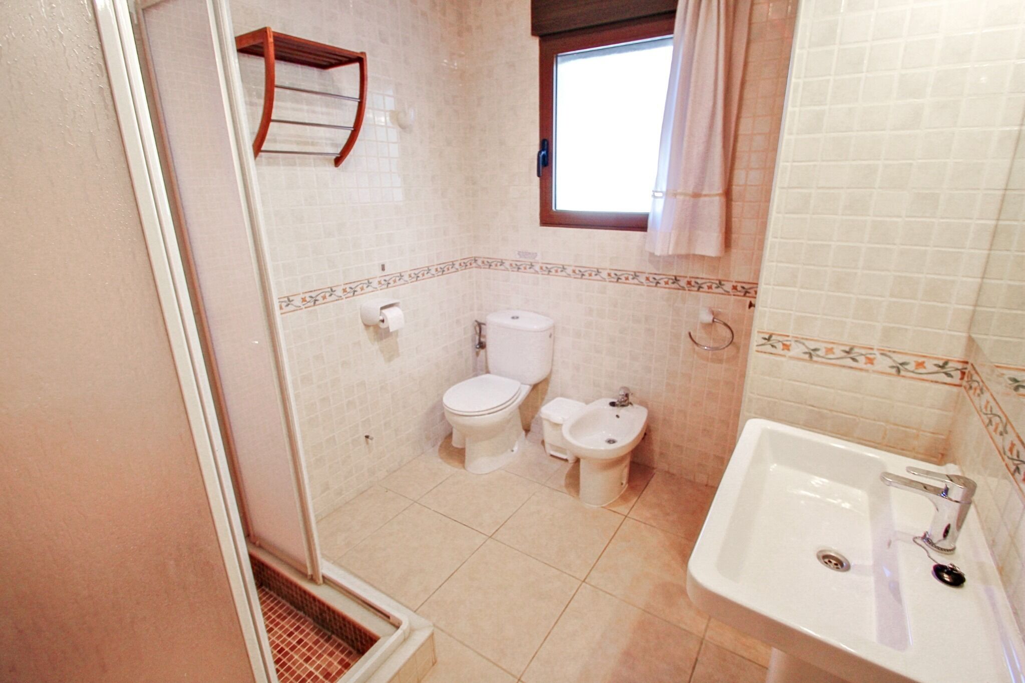 A bathroom with a toilet, bidet, and sink.