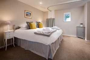 A neatly arranged bedroom with a bed, bedside table, and a cabinet.