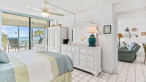 Ein Schlafzimmer mit Bett, Schminktisch, Kommode und Meerblick.