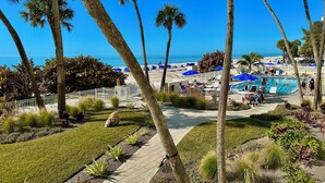 Ein Resort mit Poolbereich, Palmen und Blick auf den Strand.