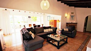 Una sala de estar con sofá, sillones, una mesa de centro y una chimenea.