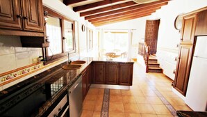 Una cocina con armarios de madera, salpicadero de azulejos y una isla central.