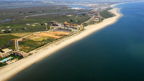 Eine Vogelperspektive eines Küstenresorts mit Strandhäusern, einer Marina und einem großen Hotelkomplex.