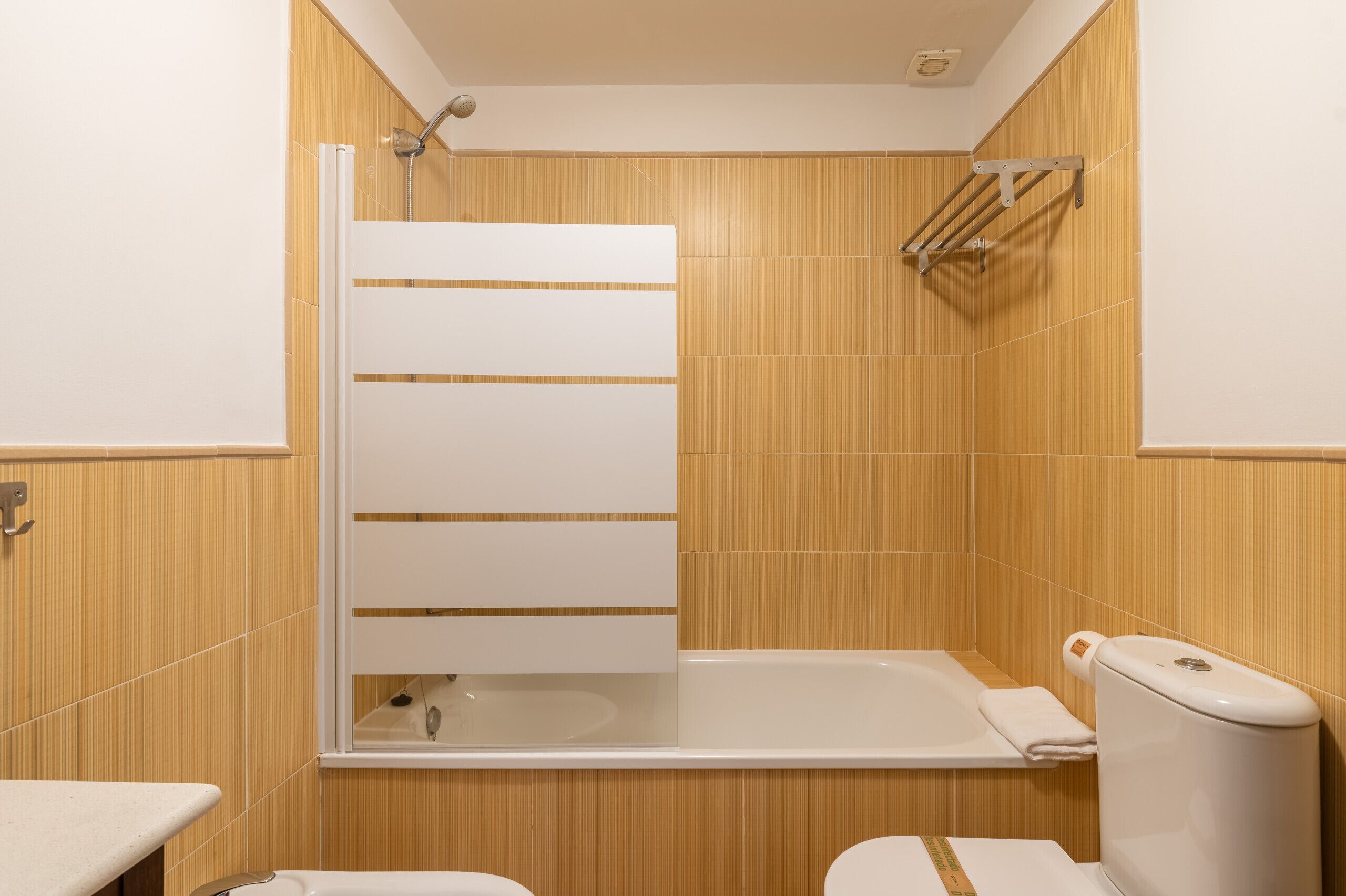 A bathroom with a shower, toilet, and sink.