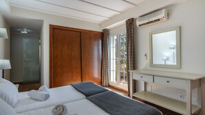 A hotel room with a bed, a vanity with a mirror, a desk, and a window with curtains. - La Quinta de Isla Canela II - Isla Canela Golf GQHII10P10 (Isla Canela)
