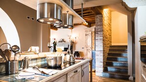 A kitchen with wooden cabinets, stainless steel appliances, and a brick wall.