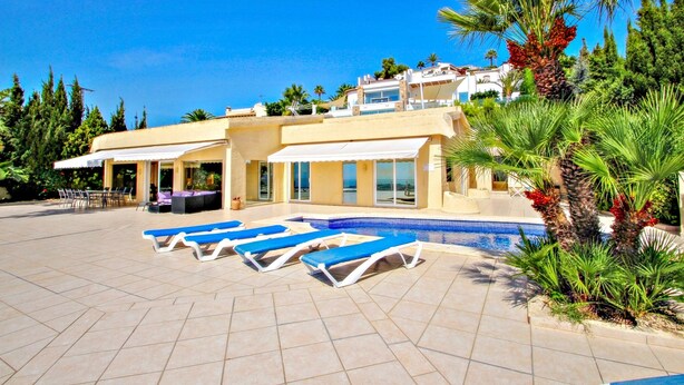Un moderno resort con piscina, tumbonas y una zona de terraza.