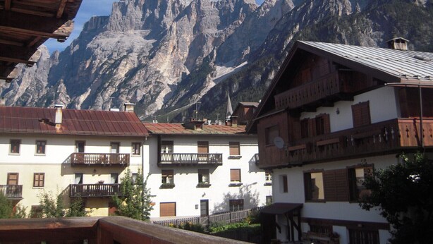 Une vue sur la montagne, avec des bâtiments en bois et un ciel dégagé.