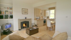 A living room with a fireplace, a television, and a bookshelf. - The ultimate secluded Holiday Cottage (Oban)