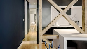 Eine moderne Küche mit Holzbalken, einer weißen Arbeitsplatte und einer dunklen Wand.