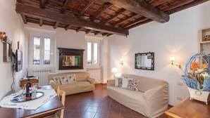 Un salon chaleureux avec deux canapés, un plafond en bois et un radiateur.