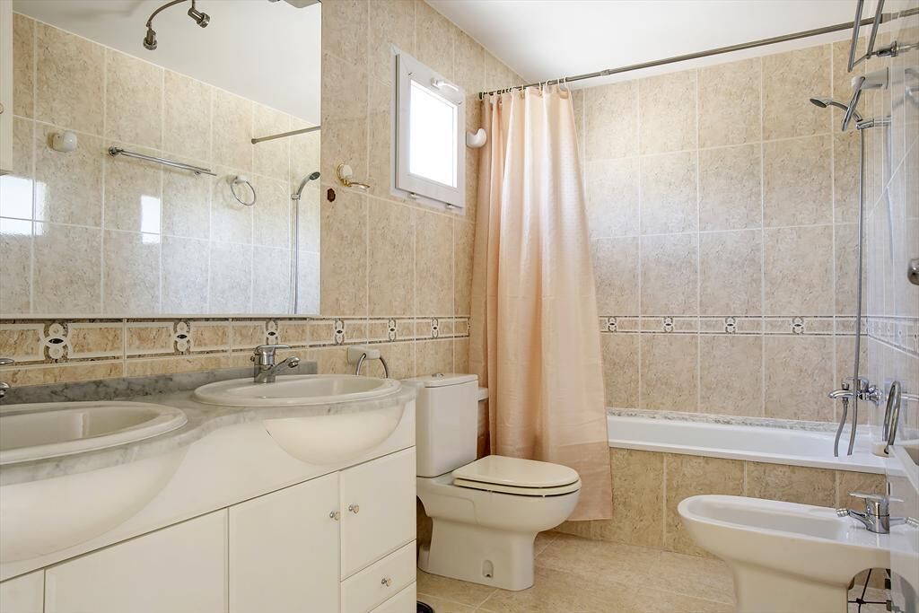 A bathroom with two sinks, a toilet, a bathtub, and a shower.