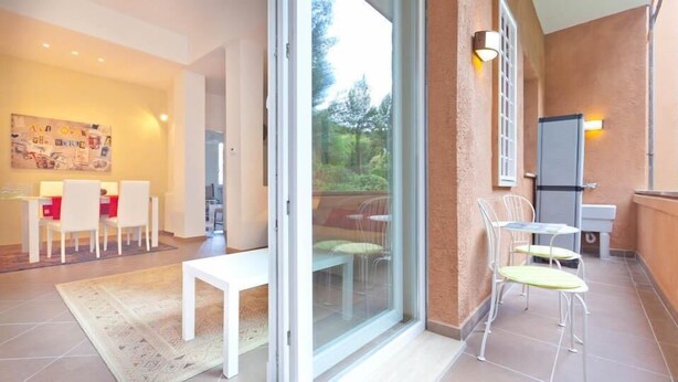 Ein modernes Interieur mit Essbereich, Küche und einem Balkon mit Sitzgelegenheit.